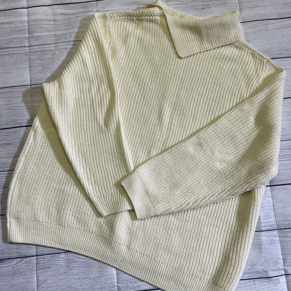 Cream colored sweater with button detail on the neck